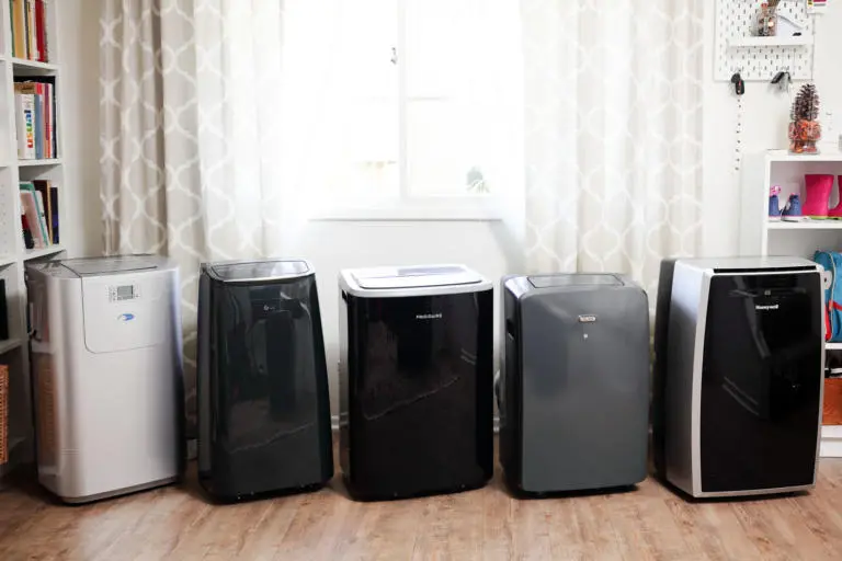 Portable dual-hose heat pump sitting beneath a window kit in a cozy apartment